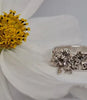 Handcrafted floral silver ring resting on a soft flower petal
